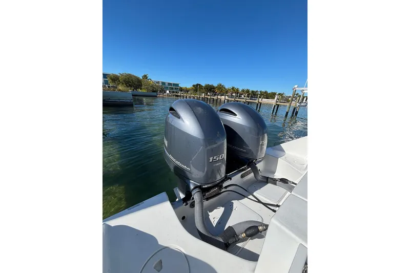 Slide: The Image of 2018 Sea Hunt Gamefish 25 with twin outboard motors docked by the water. - 14