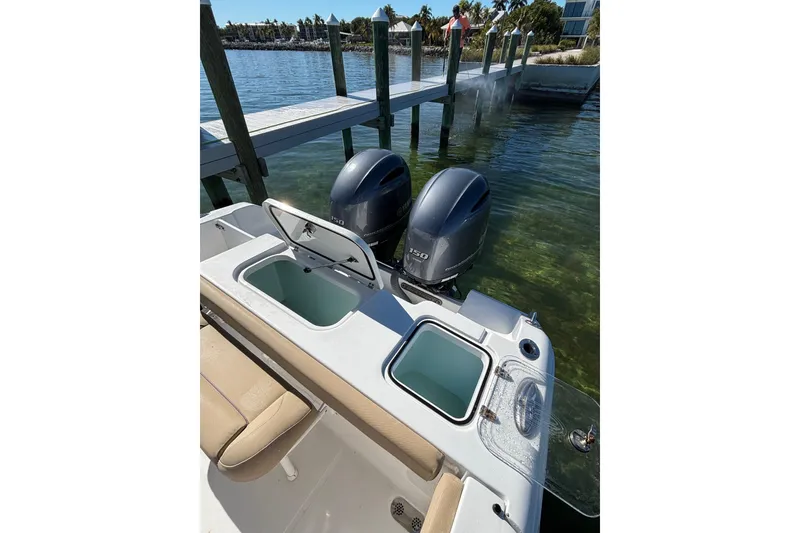 Slide: The Image of 2018 Sea Hunt Gamefish 25 boat with dual engines docked by a pier. - 16
