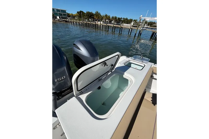 Slide: The Image of 2018 Sea Hunt Gamefish 25 boat with open storage compartment and twin Yamaha 150 engines. - 17