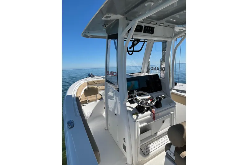 Slide: The Image of 2018 Sea Hunt Gamefish 25 boat interior with steering console on calm ocean. - 21