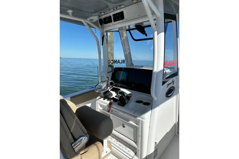 Slide: The Image of 2018 Sea Hunt Gamefish 25 boat cockpit with steering wheel and navigation controls. - 9