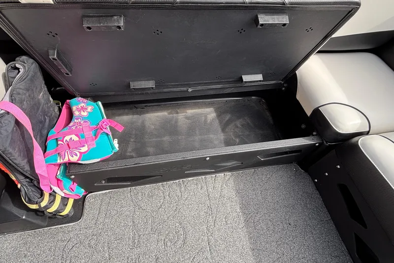Slide: The Image of Open storage compartment in a 2012 Axis A22 boat with colorful life jackets. - 13