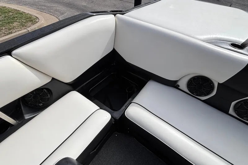 Slide: The Image of 2012 Axis A22 boat interior with white seating and built-in speakers. - 14