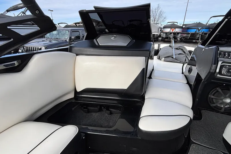 Slide: The Image of 2012 Axis A22 boat interior with white seating and storage compartment open. - 18