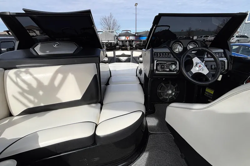 Slide: The Image of 2012 Axis A22 boat interior with steering wheel, dashboard, and seating. - 24