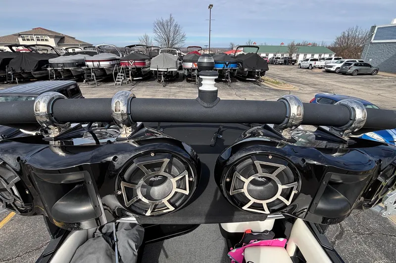 Slide: The Image of 2012 Axis A22 boat with speakers, parked among other boats in a dealership lot. - 34