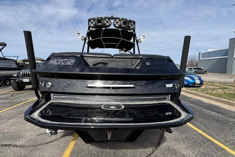 Slide: The Image of 2012 Axis A22 boat rear view in parking lot, showcasing sleek design and speakers. - 35