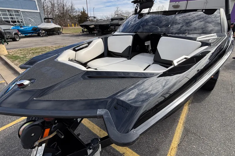Slide: The Image of 2012 Axis A22 boat with sleek black design and white interior, parked outdoors. - 39