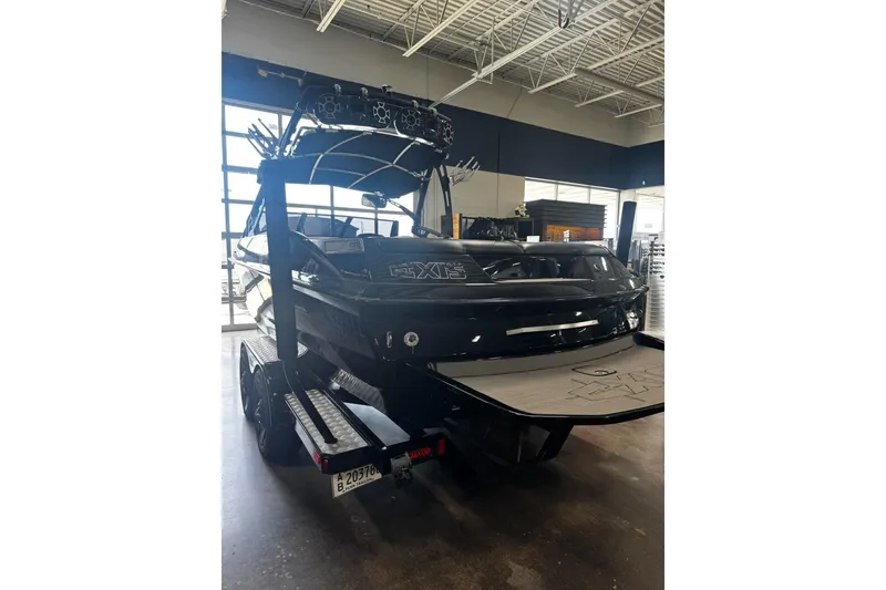 Slide: The Image of 2012 Axis A22 boat in showroom, black exterior, on trailer, indoor lighting. - 47