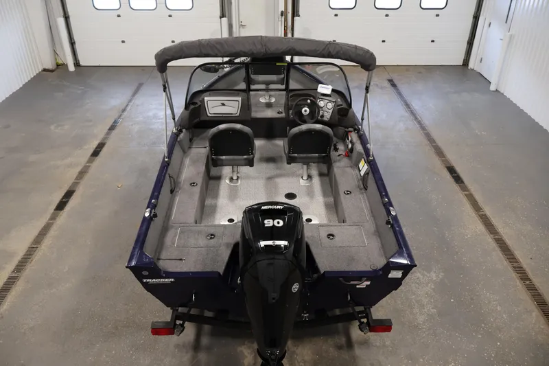 Slide: The Image of 2024 Tracker Pro Guide V-16 WT boat in a garage, featuring dual seats and a Mercury engine. - 10