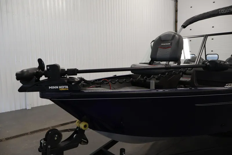 Slide: The Image of 2024 Tracker Pro Guide V-16 WT boat with Minn Kota Terrova motor in a garage. - 11