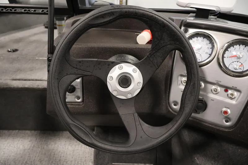 Slide: The Image of 2024 Tracker Pro Guide V-16 WT boat dashboard with steering wheel and gauges. - 22