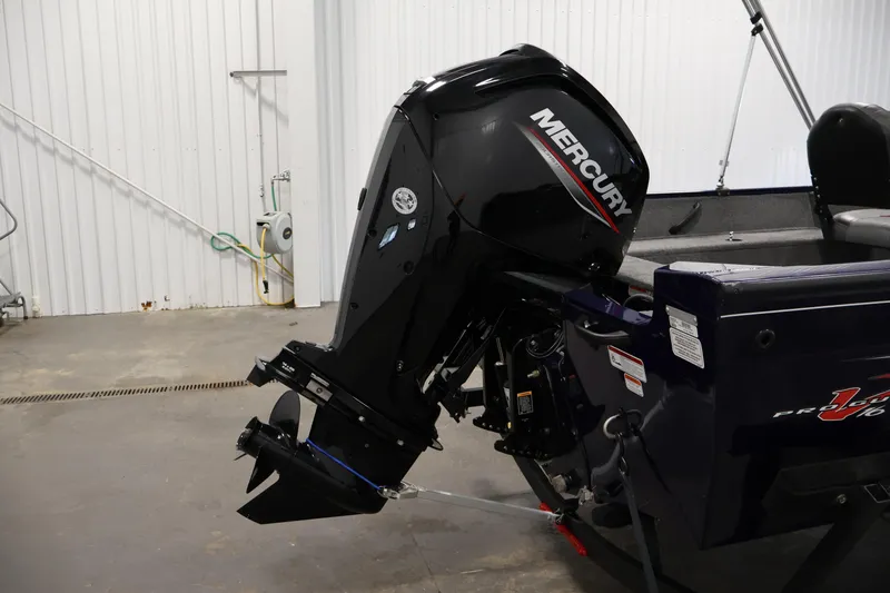 Slide: The Image of 2024 Tracker Pro Guide V-16 WT boat with Mercury outboard motor in a garage setting. - 37