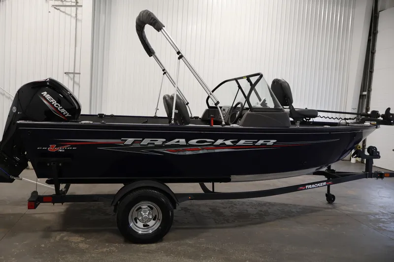 Slide: The Image of 2024 Tracker Pro Guide V-16 WT boat with Mercury engine in a showroom. - 4