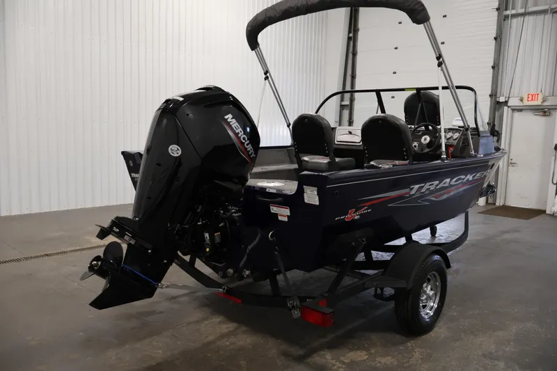 Slide: The Image of 2024 Tracker Pro Guide V-16 WT boat with Mercury engine in a garage setting. - 5
