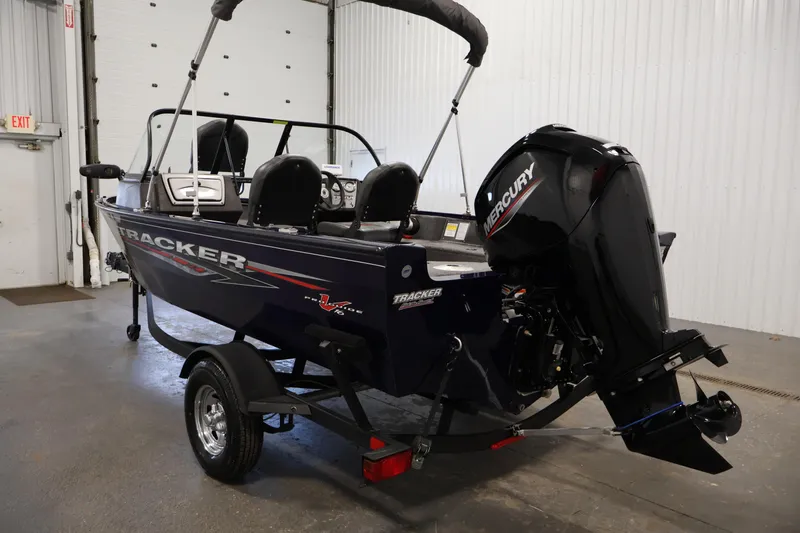 Slide: The Image of 2024 Tracker Pro Guide V-16 WT boat with Mercury engine in a garage setting. - 7