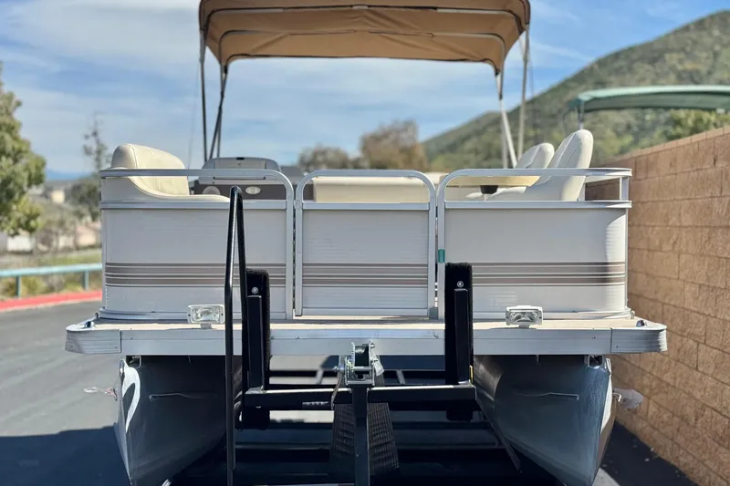 Slide: The Image of 1999 Godfrey Parti Kraft 240 ES pontoon boat with canopy, parked on a trailer. - 2