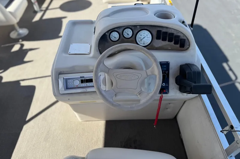 Slide: The Image of 1999 Godfrey Parti Kraft 240 ES boat dashboard with steering wheel and control panel. - 21