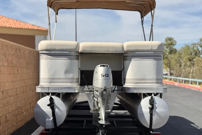 Slide: The Image of 1999 Godfrey Parti Kraft 240 ES pontoon boat with Honda outboard motor, parked outdoors. - 5