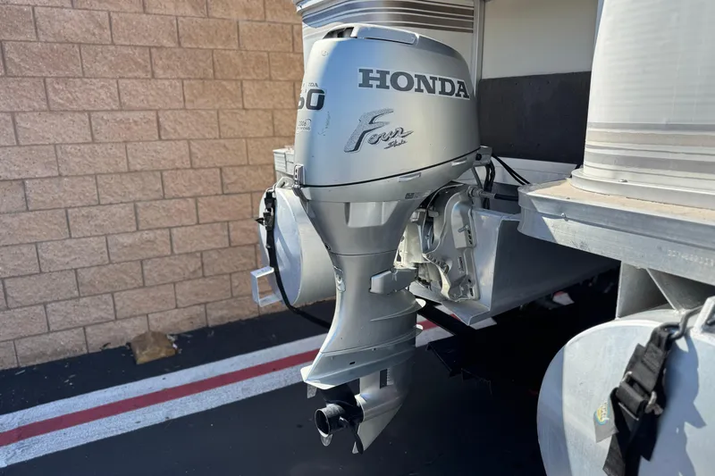 Slide: The Image of 1999 Godfrey Parti Kraft 240 ES with Honda outboard motor, parked on pavement. - 7