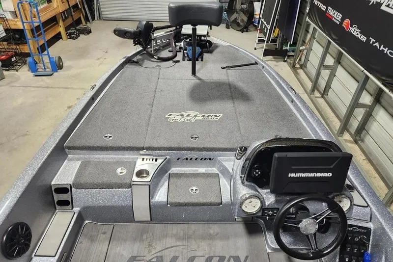 Slide: The Image of 2019 Falcon F195 boat interior with Humminbird electronics and steering wheel in a garage setting. - 10