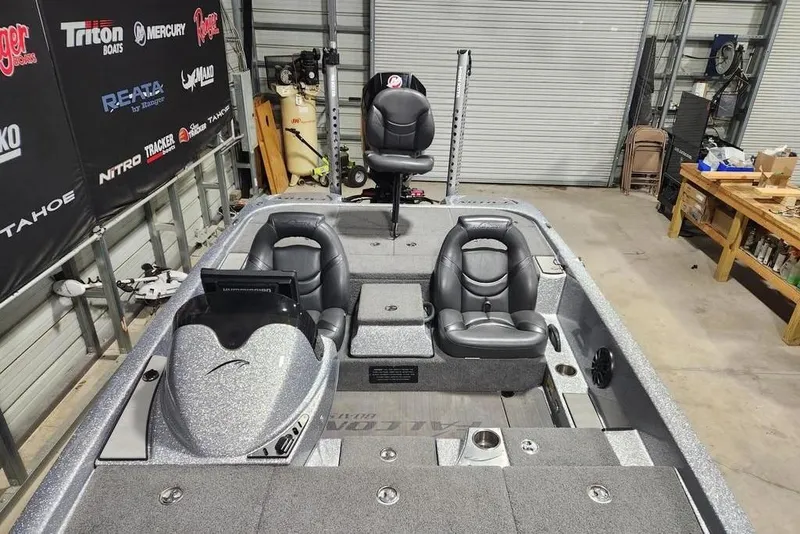 Slide: The Image of 2019 Falcon F195 boat interior with gray seating and control panel in a workshop. - 15