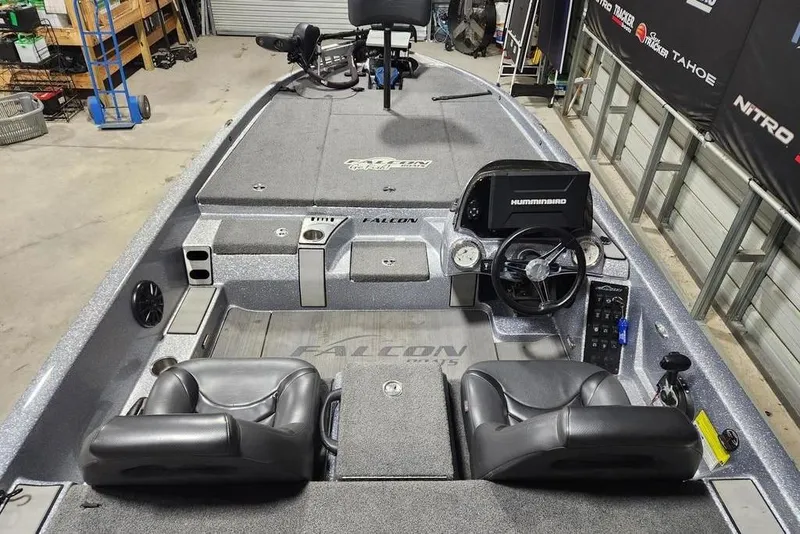 Slide: The Image of 2019 Falcon F195 boat interior with dual seats, steering wheel, and control panel in a garage setting. - 7
