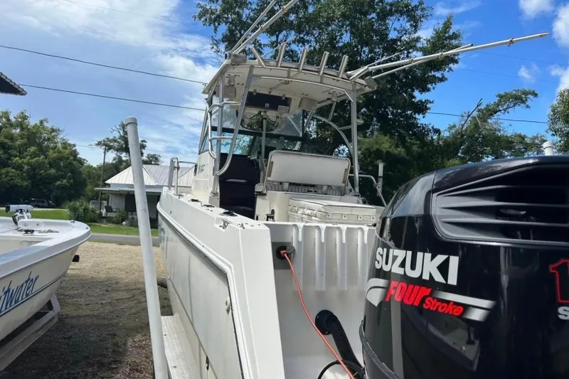 Slide: The Image of 1997 Sea Cat SL5C boat with Suzuki Four Stroke engine, parked outdoors. - 4