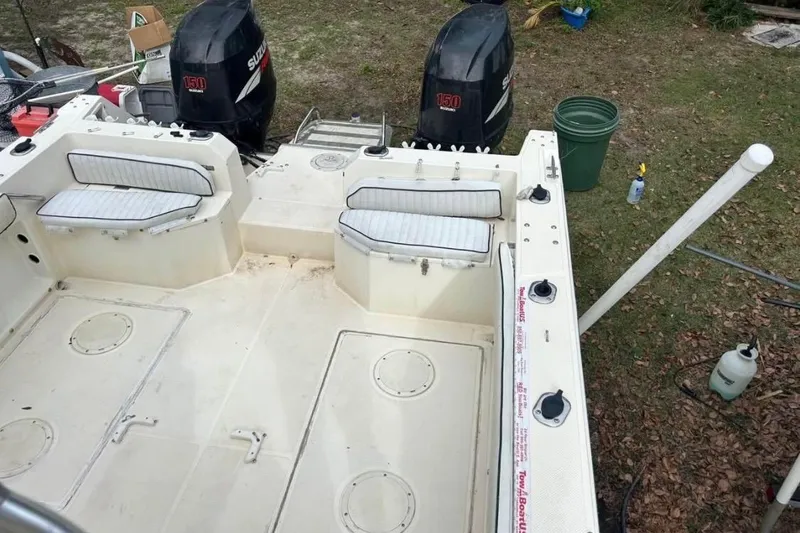 Slide: The Image of 1997 Sea Cat SL5C boat interior with twin Suzuki 150 engines, white seating, and storage compartments. - 6