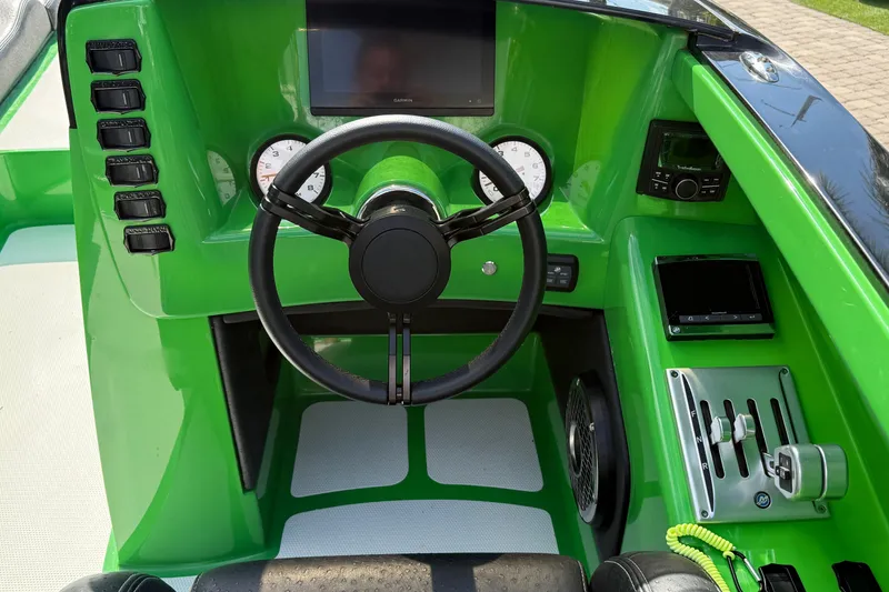 Slide: The Image of Green dashboard of 2021 E-Ticket 29 boat with steering wheel and controls. - 11