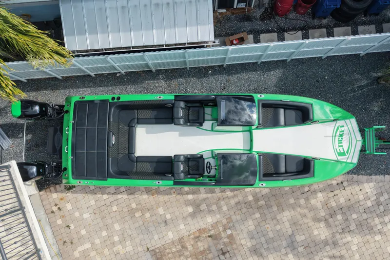 Slide: The Image of Aerial view of a 2021 E-Ticket 29 boat with green accents, docked on a paved surface. - 13