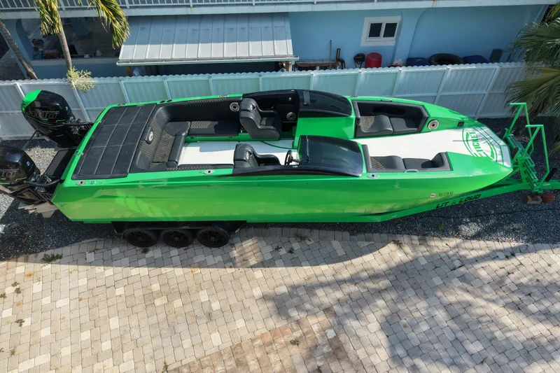 Slide: The Image of Green 2021 E-Ticket 29 boat with dual engines, parked on a paved driveway. - 4