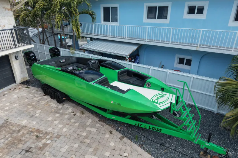 Slide: The Image of Green 2021 E-Ticket 29 boat on trailer, parked in a residential driveway. - 5