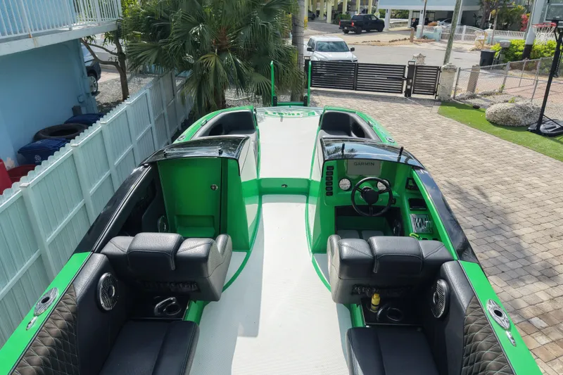 Slide: The Image of 2021 E-Ticket 29 boat with green and black interior, parked in a driveway. - 7