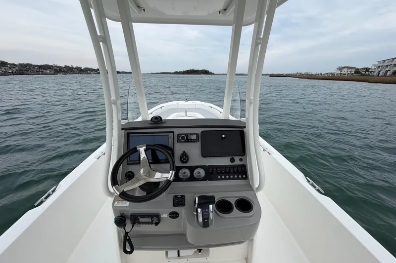 Slide: The Image of 2016 Boston Whaler 240 Dauntless boat console with steering wheel on open water. - 16