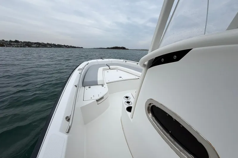 Slide: The Image of 2016 Boston Whaler 240 Dauntless boat on calm water, showcasing sleek design and spacious deck. - 18