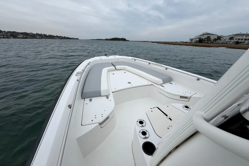 Slide: The Image of 2016 Boston Whaler 240 Dauntless boat on calm water, featuring spacious seating and sleek design. - 19