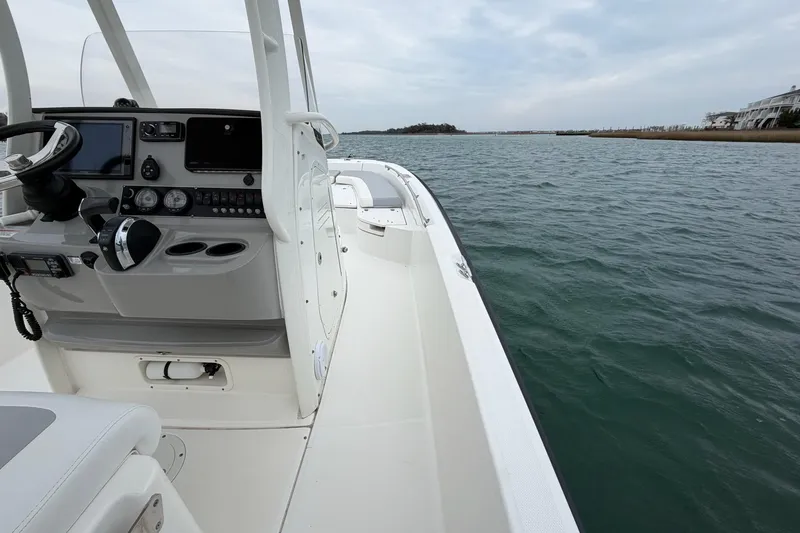 Slide: The Image of 2016 Boston Whaler 240 Dauntless boat on water, featuring helm and open deck. - 20