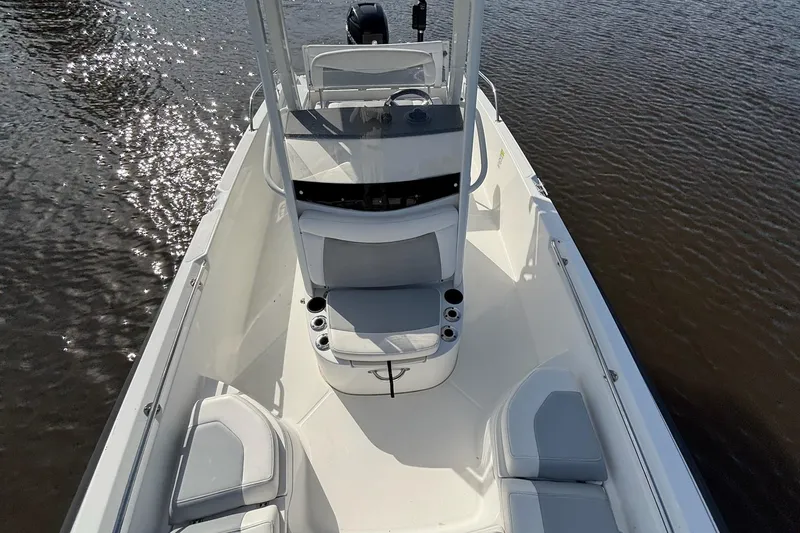 Slide: The Image of 2016 Boston Whaler 240 Dauntless boat on calm water, showcasing sleek design and seating. - 23