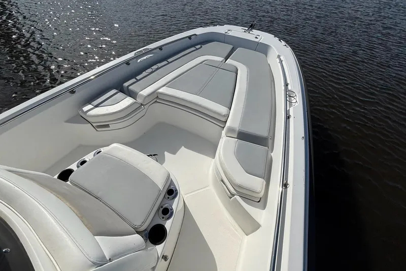 Slide: The Image of 2016 Boston Whaler 240 Dauntless boat interior with cushioned seating on calm water. - 26