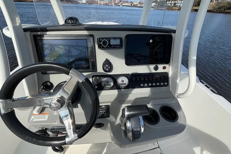 Slide: The Image of 2016 Boston Whaler 240 Dauntless boat console with steering wheel and navigation controls. - 28
