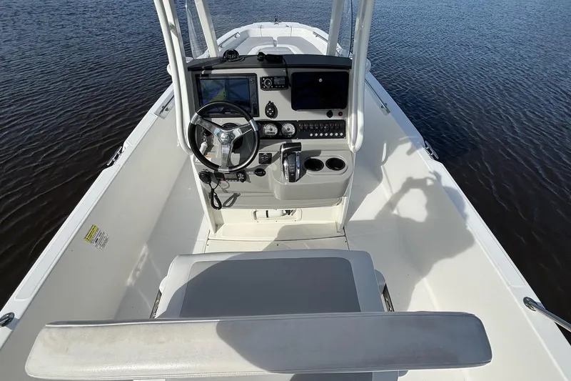 Slide: The Image of 2016 Boston Whaler 240 Dauntless boat interior with steering console on calm water. - 29