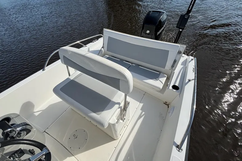 Slide: The Image of 2016 Boston Whaler 240 Dauntless boat interior with seating and motor on water. - 30