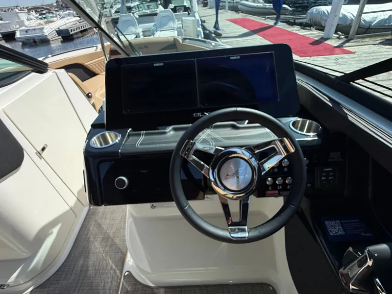 Slide: The Image of The image shows the helm of a Sea Ray SLX 280 boat at a marina. - 37
