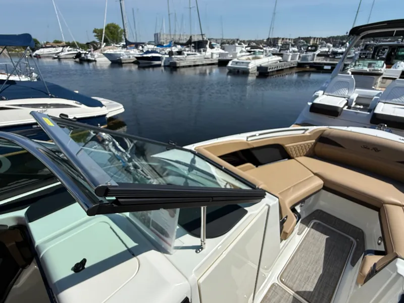 Slide: The Image of A Sea Ray SLX 280 boat docked in a marina, surrounded by other boats. - 50