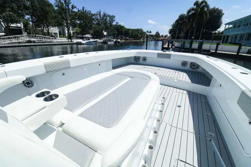 Slide: The Image of 2022 Freeman 47 boat interior with modern seating and navigation system, docked by waterfront homes. - 25