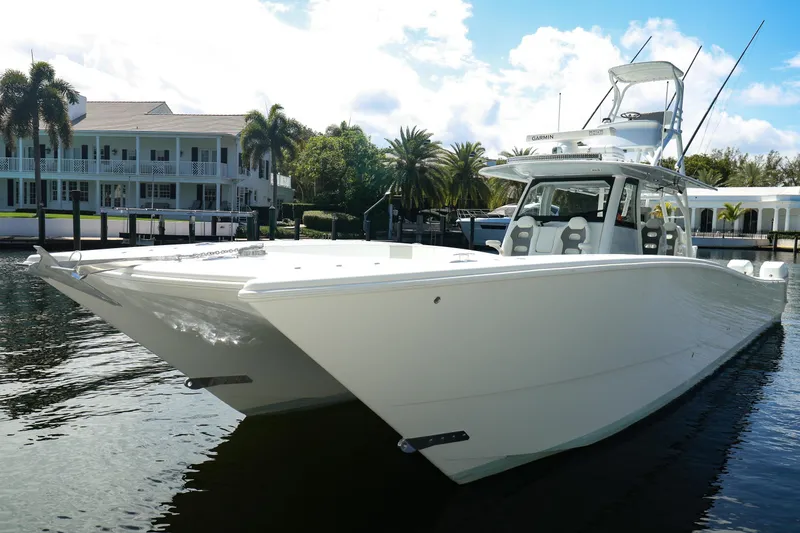 Slide: The Image of 2022 Freeman 47 boat with clear enclosure, docked near waterfront homes. - 50