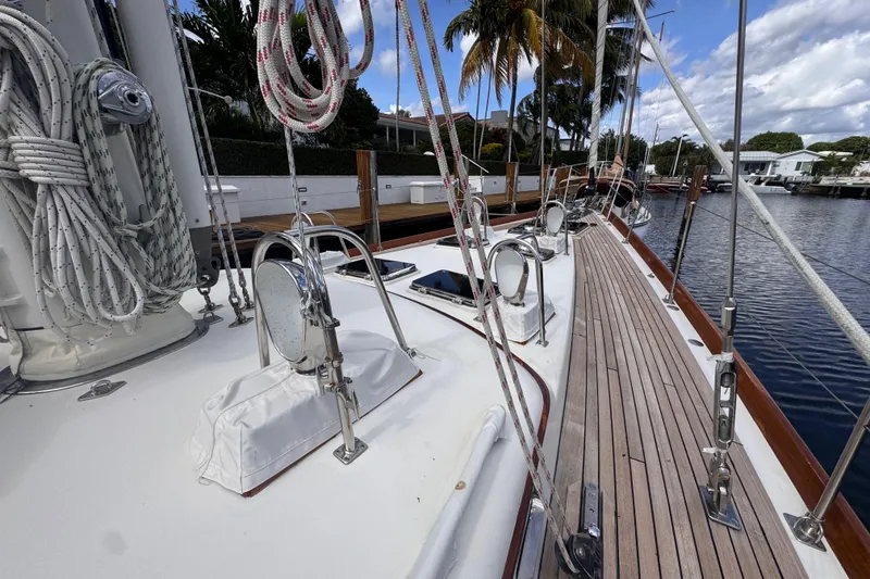 Slide: The Image of 1989 Little Harbor Sloop 58' deck with ropes and wooden details, docked by water. - 26