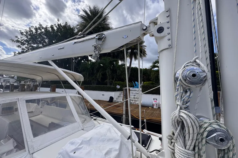 Slide: The Image of 1989 Little Harbor Sloop 58' sailboat with rigging and canopy, docked near palm trees. - 28
