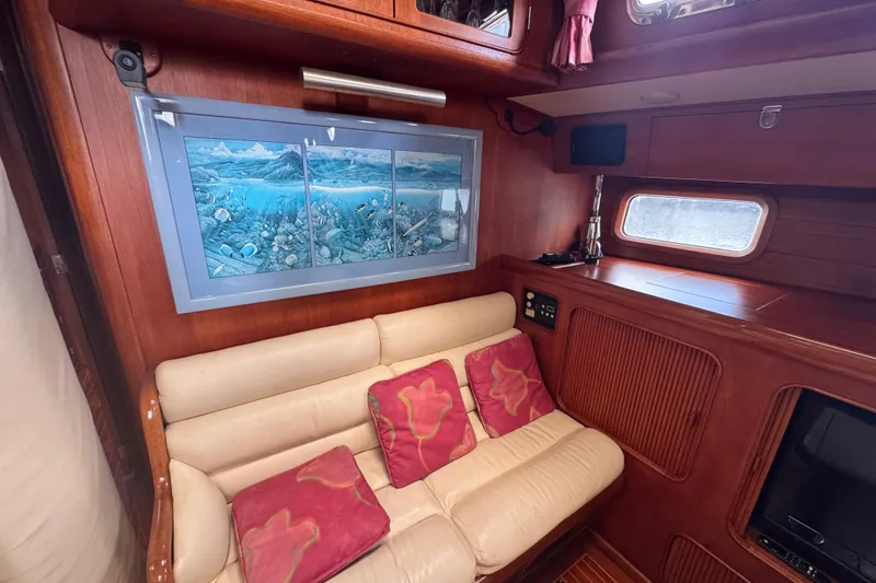 Slide: The Image of Interior of 1989 Little Harbor Sloop, featuring cozy seating and nautical artwork. - 49